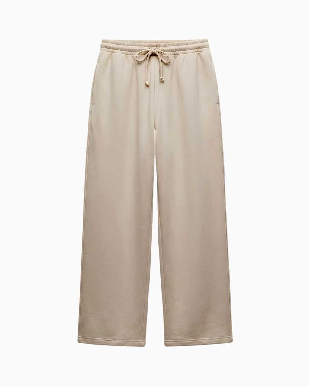 A pair of wide-leg sweatpants in a light beige or oatmeal color, featuring an elastic waistband with a matching drawstring, shown against a plain white background.