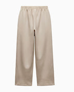 A pair of wide-leg cropped pants in a light beige or sand color, featuring an elastic waistband, shown against a plain white background.