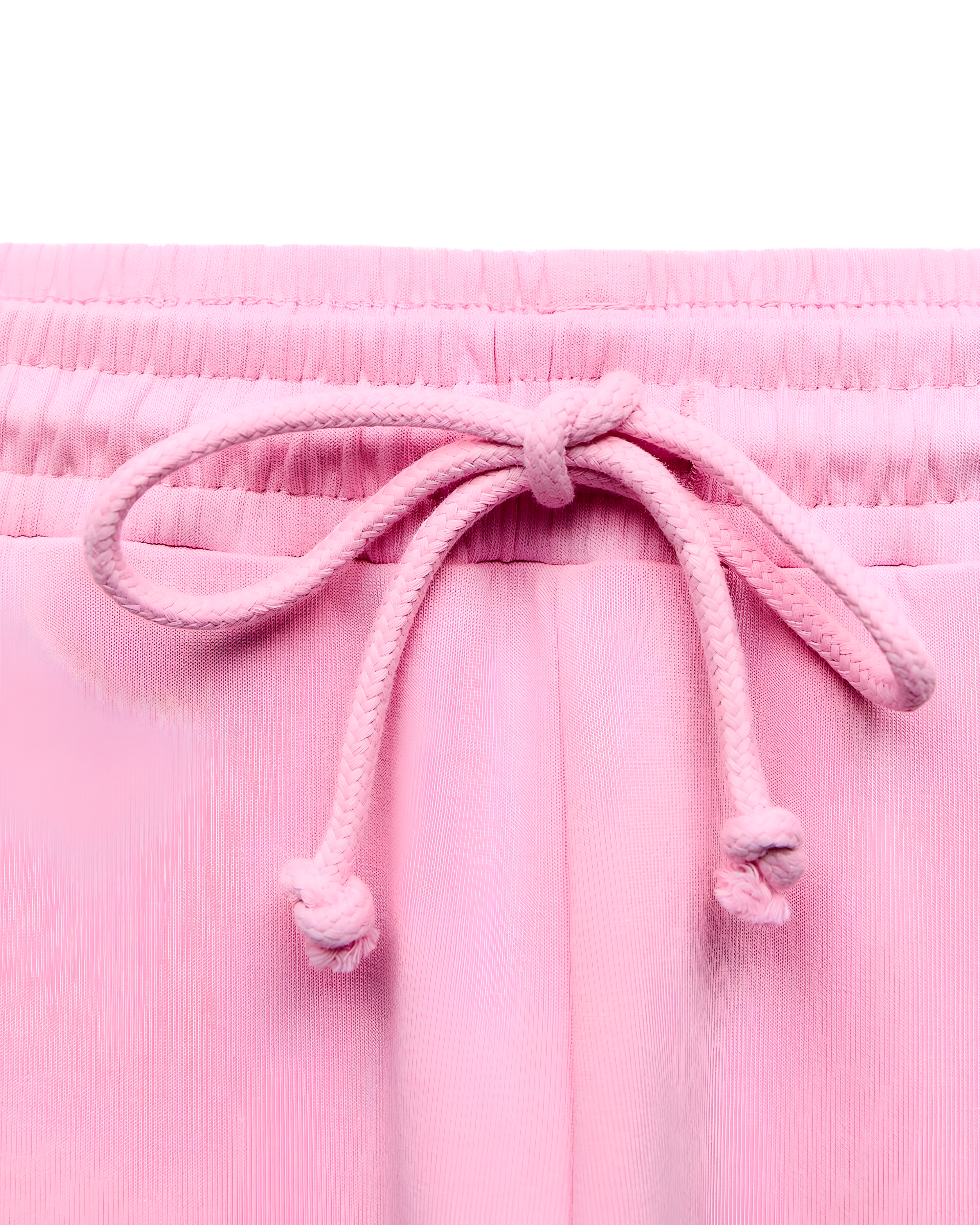 Close-up of a pair of light pink pants or shorts showing the elastic waistband and matching pink drawstring tied in a bow.