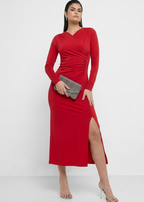 Woman wearing a red dress with a slit on a white background